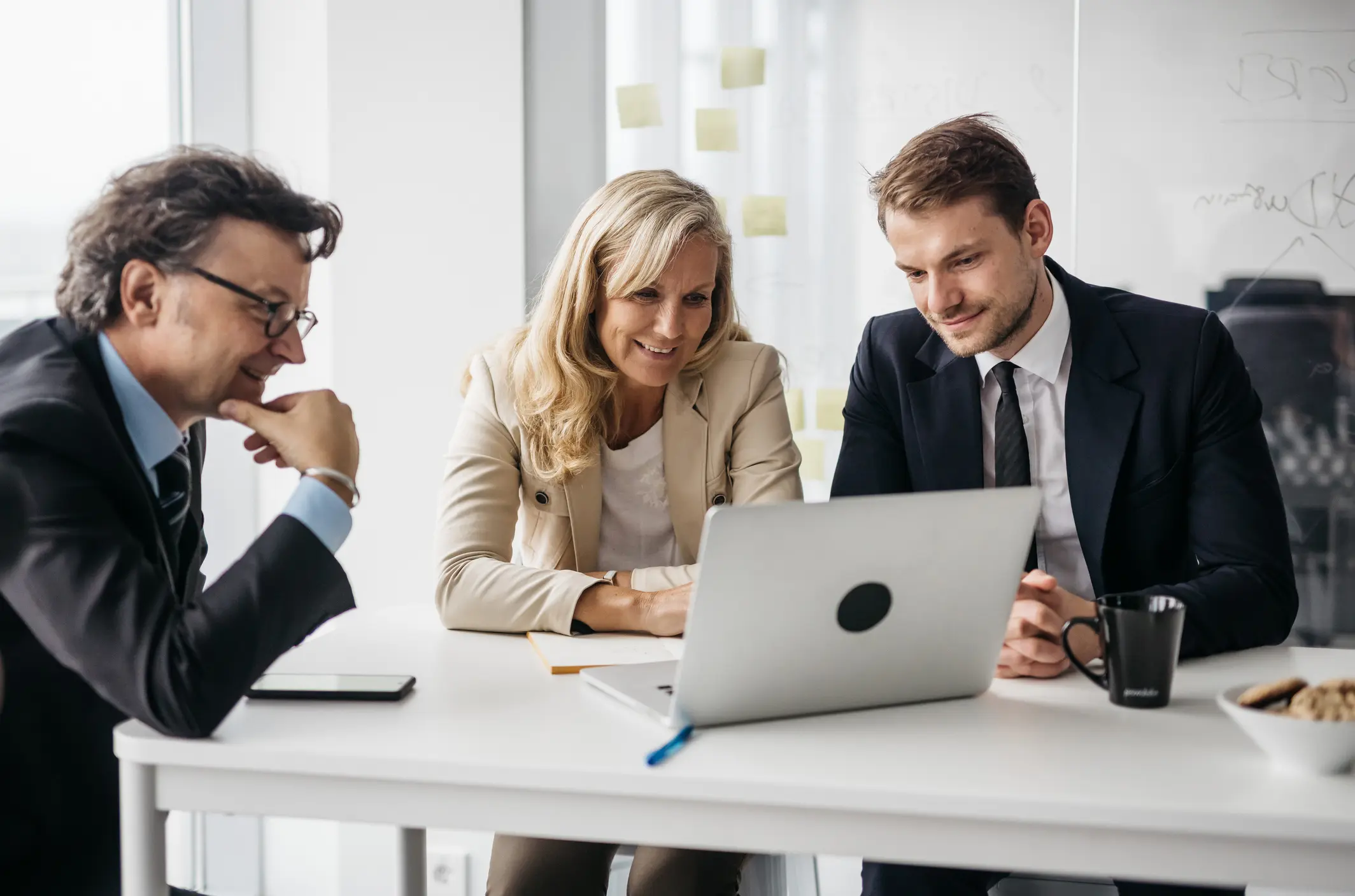 Business meeting with three colleagues at laptop.